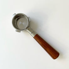 Load image into Gallery viewer, A Delonghi Dedica bottomless portafilter with an almond solid wood handle and stainless steel basket.