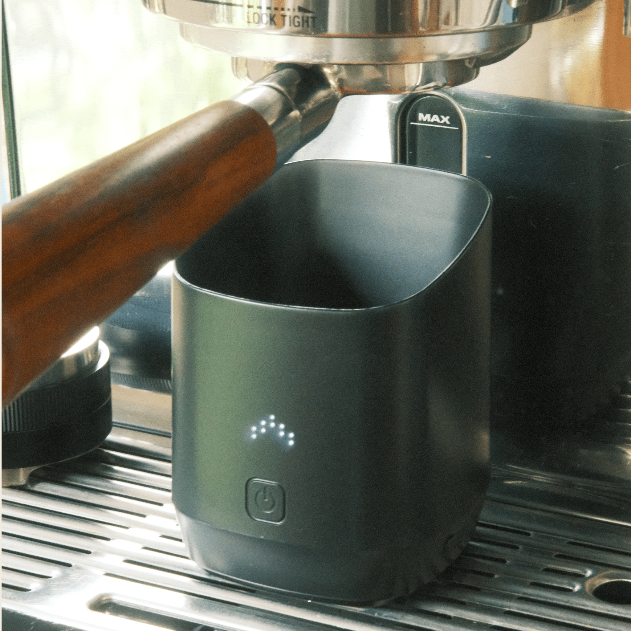 Coffee scales and dosing cup beside a home espresso machine